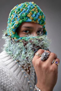 a man wearing a knitted beanie and jewelry