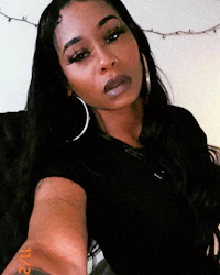 a woman wearing a black shirt and hoop earrings