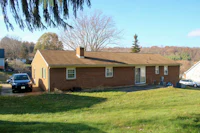 a brick house on a grassy hill