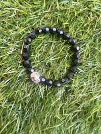 a black beaded bracelet with a skull on it