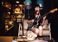 a woman playing an electric guitar in a room