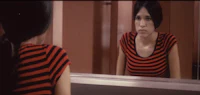 a woman is standing in front of a mirror