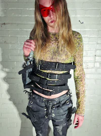 a woman in a leather outfit holding a gun