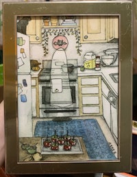 a person is holding up a picture of a woman in a kitchen