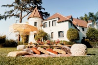 a table with chairs and a blanket in front of a house