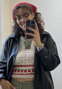 a woman taking a selfie wearing a crocheted strawberry crop top