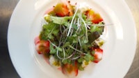 a plate with a strawberry salad on it