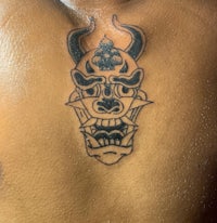 a man with a tattoo of a demon on his back