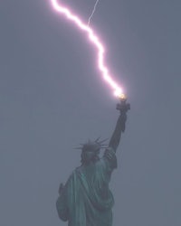 the statue of liberty is being struck by a lightning bolt