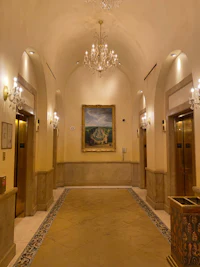 a hallway with a chandelier and a painting