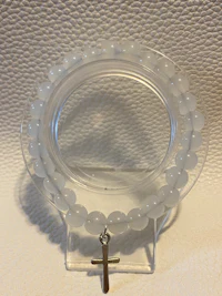 a clear glass bead holder on a white surface