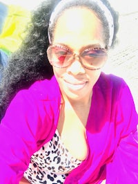 a woman wearing a pink jacket and sunglasses