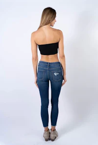 the back view of a woman wearing a black top and jeans