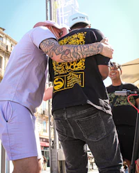 a man is hugging a man on a scooter