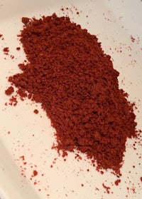 a pile of red powder on a white plate