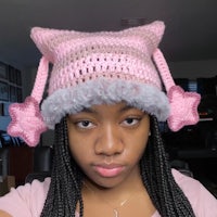 a young woman wearing a crocheted pink cat hat