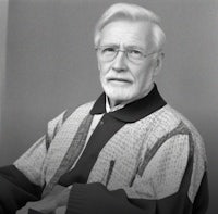 a black and white photo of an older man with glasses