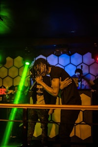 two men standing on stage at a nightclub