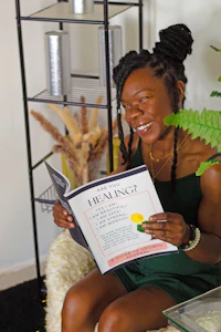 a woman is sitting on a chair reading a book