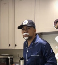 a man in a blue pajama shirt is making a face in the kitchen