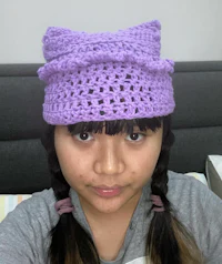 a girl wearing a purple crocheted hat