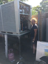 a woman standing next to a large air conditioner