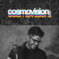 cosmovision - a man smiling in front of a microphone