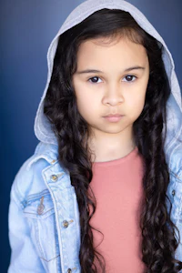 a young girl in a hoodie is posing for a photo