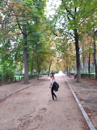 a woman walking down a path in a park