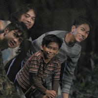 a group of young boys are posing in front of a tree