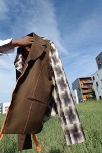 a person is holding a jacket in a field