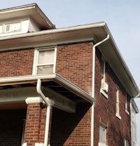 a brick house with a porch and a roof