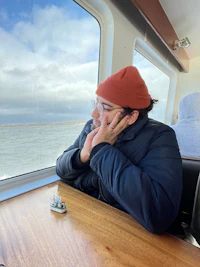 a man sitting at a table looking out at the ocean