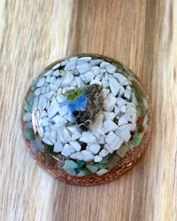 a blue and green glass ball with a stone in it
