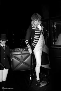 a man in a costume is standing next to a horse drawn carriage