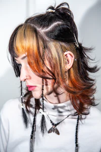 a woman with orange and black hair is wearing a headband