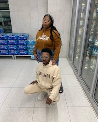 a man and woman posing for a photo in a grocery store