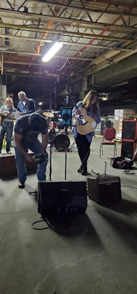 a group of people playing music in a warehouse