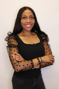 a young woman wearing a black top with polka dot sleeve