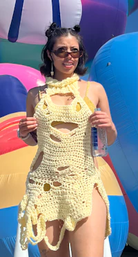 a woman in a crocheted dress holding a balloon