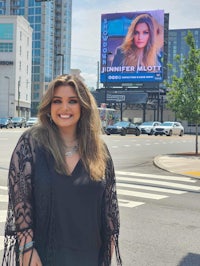 a woman standing in front of a billboard