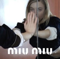 a woman is holding her hand in front of a mirror