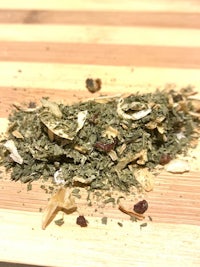a pile of dried herbs on a wooden cutting board
