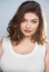 a woman in a white tank top posing for a photo