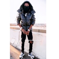 a man wearing a black jacket and a black mask