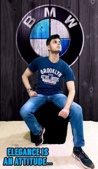 a man sitting on a stool with a bmw logo on it