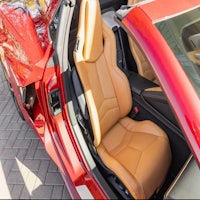 the interior of a red sports car with leather seats