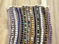 a row of different colored beads on a wooden table