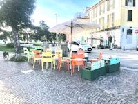 a group of tables and chairs on a cobblestone street