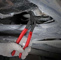 a person is using pliers to repair a car